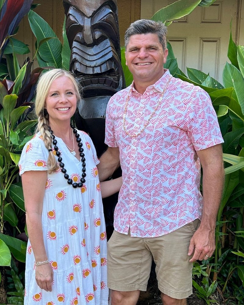 Eric and his wife Krissy smiling together in front of tropical plants